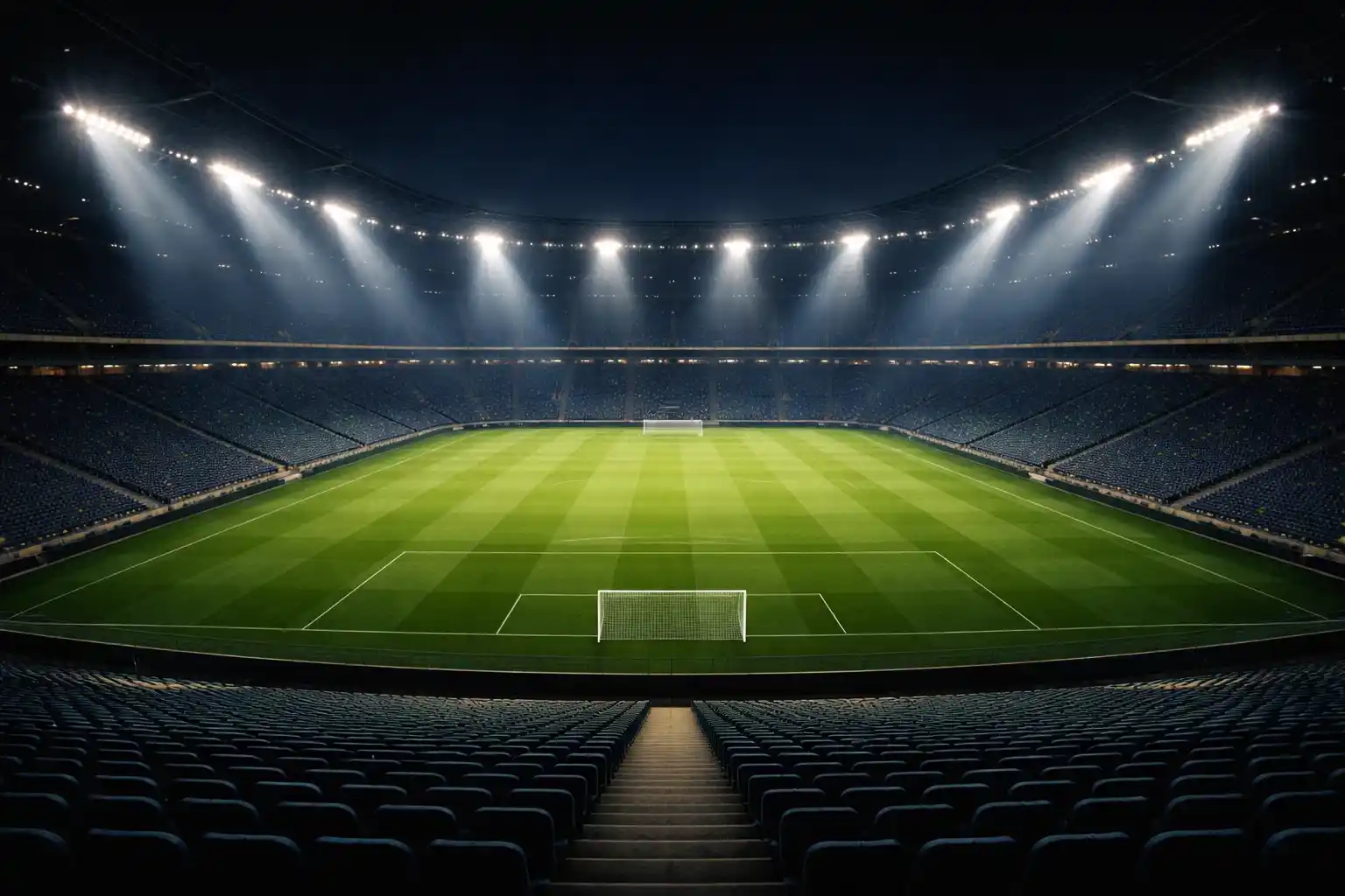 Stadio di calcio illuminato di notte con riflettori accesi sul campo verde